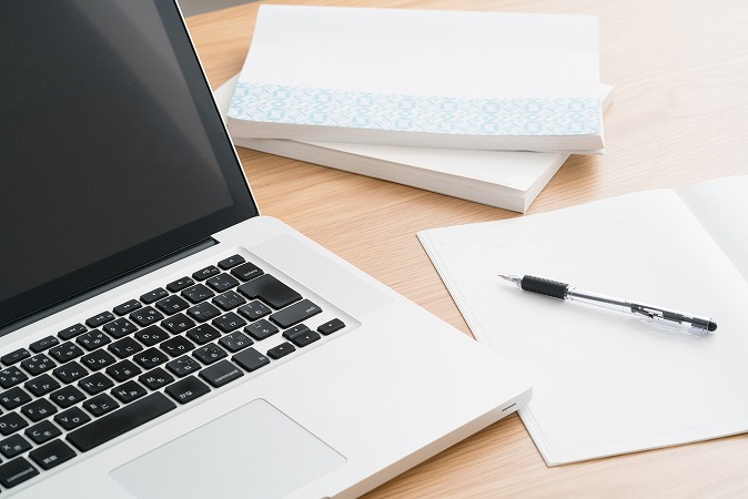 ノートパソコンとメモとペン